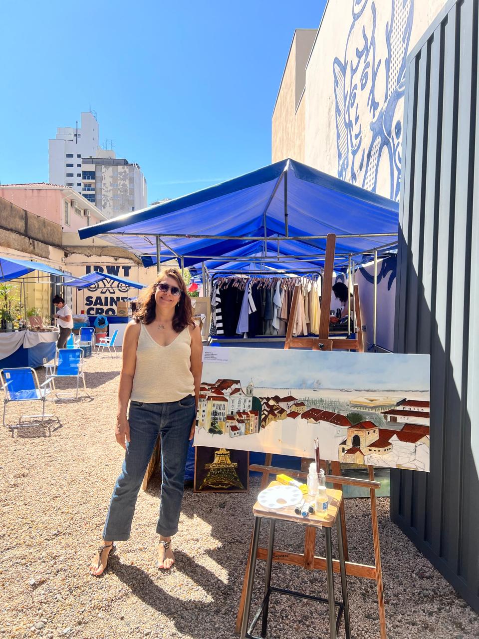 Artista visual com pintura em exposição